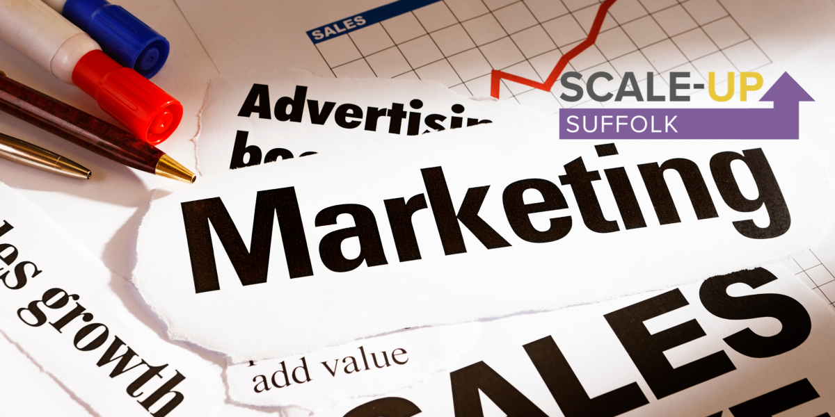 Marketing and saled text on table top with pens showing with paper cut out.