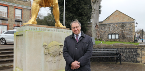 Person standing in front of Thomas Paine statue in Thetford